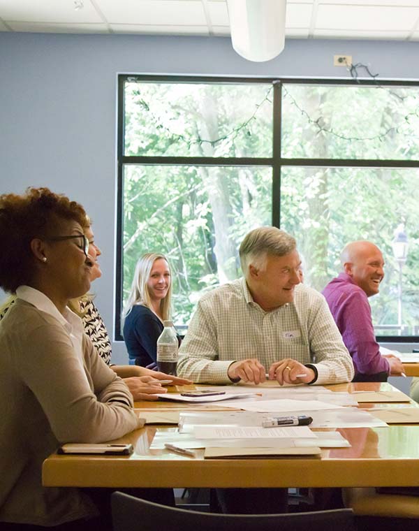 Course attendees sitting around a table, smiling