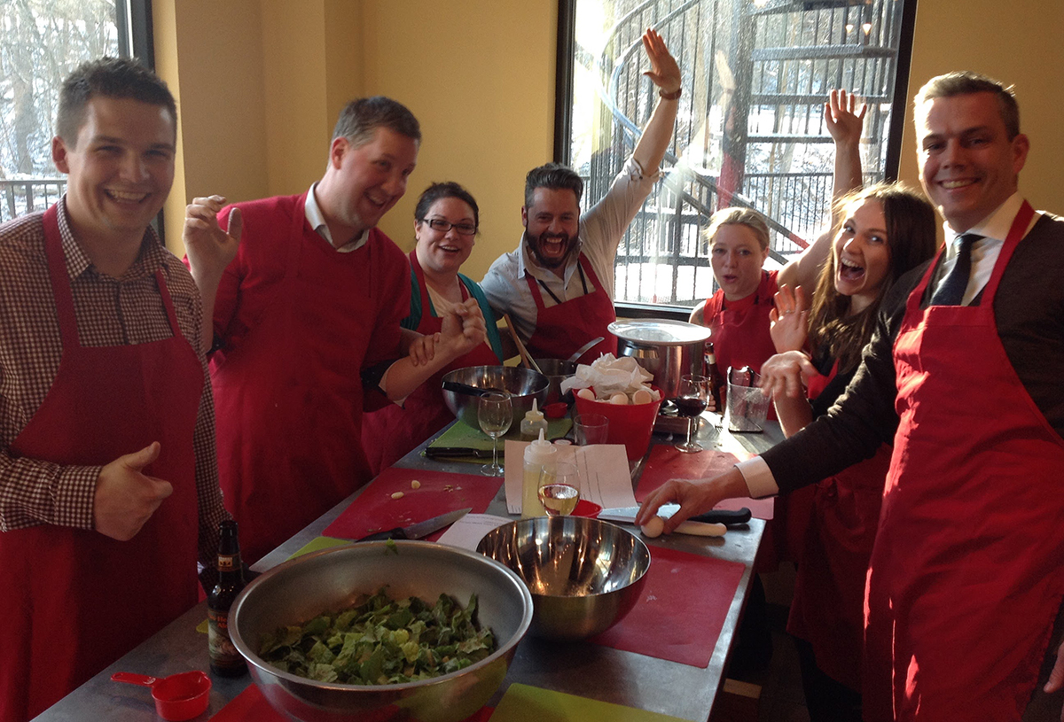 Happy team cooking at a Thought Design culinary program