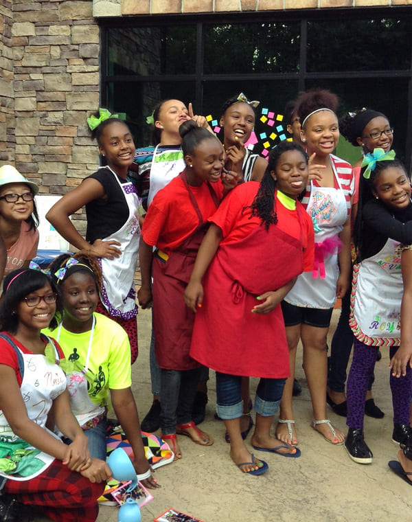 Group photo of kids in aprons in front of the Thought Design Culinary Kitchen