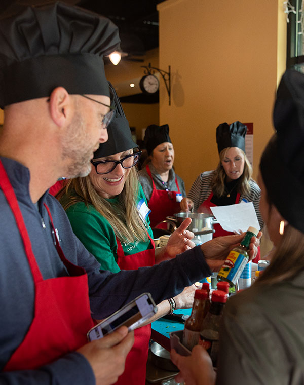 Cooking class attendees looking at sauces