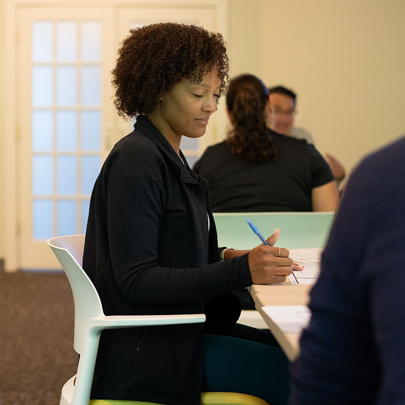 Young woman sitting at a desk during a Thought Design Workshop